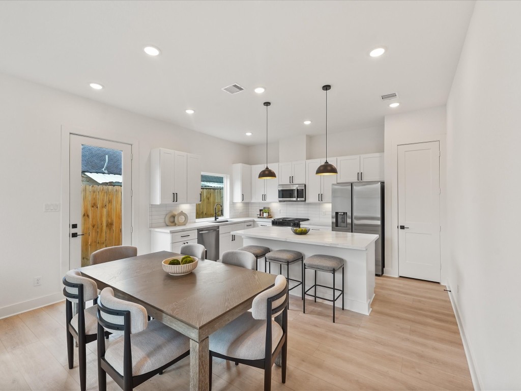 243 Rebecca Street, Unit F Houston, TX 77022 - Photo 2 of 26 a kitchen with a table and chairs in it