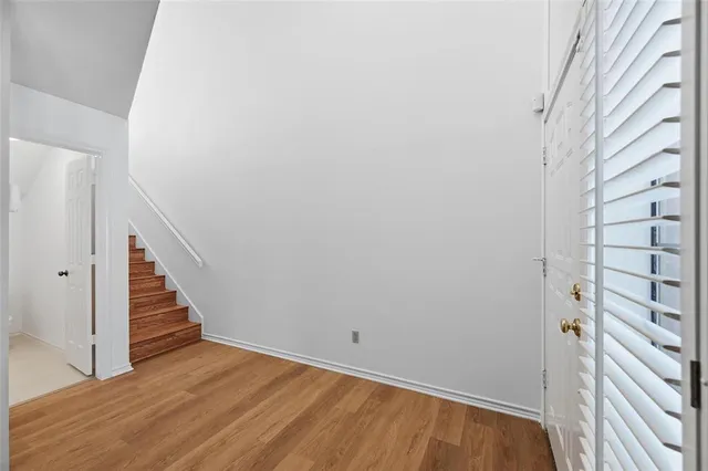 a view of a hallway with wooden floor and entryway