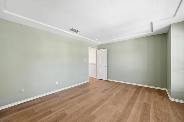 a view of an empty room with wooden floor