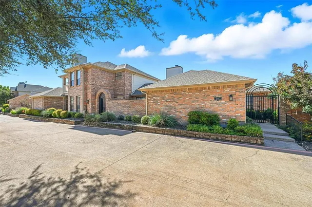 a front view of a house with a garden and yard
