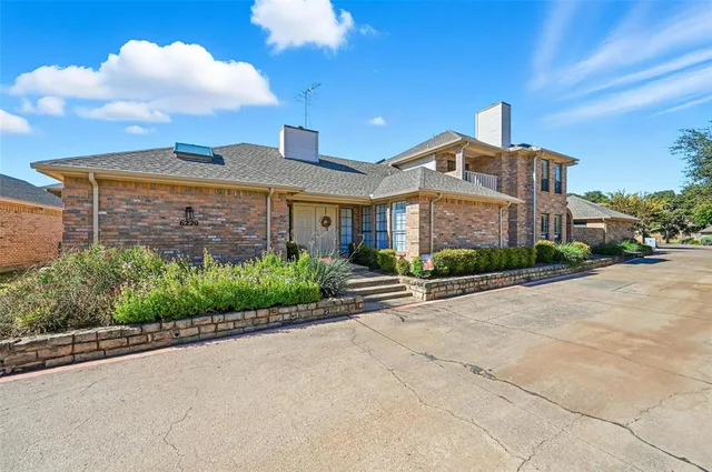 a front view of a house with a yard and potted plants