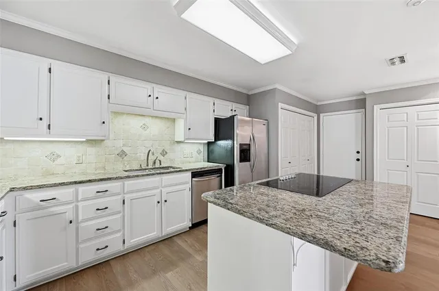a kitchen with granite countertop a sink and cabinets