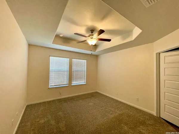 an empty room with windows and ceiling fan