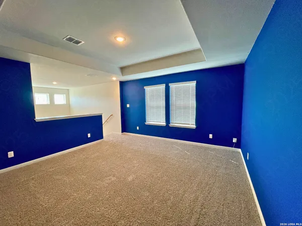 a view of empty room with wooden floor and windows