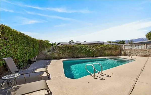 a view of a swimming pool with an outdoor seating and a yard