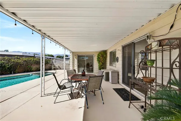 a view of a patio with a dining table and chairs with wooden floor