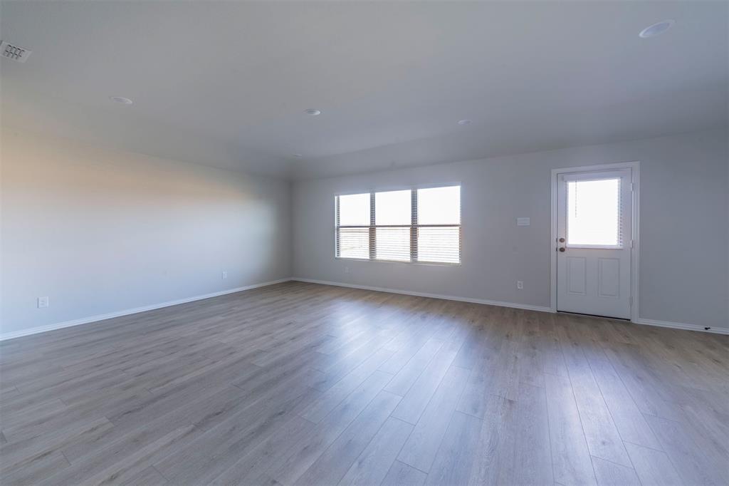 516 Ridgewood Drive Van Alstyne, TX 75495 - Photo 2 of 25 a view of an empty room with wooden floor and window