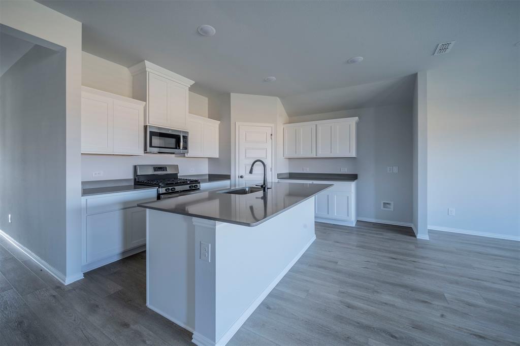 516 Ridgewood Drive Van Alstyne, TX 75495 - Photo 9 of 25 a kitchen with kitchen island white cabinets and sink