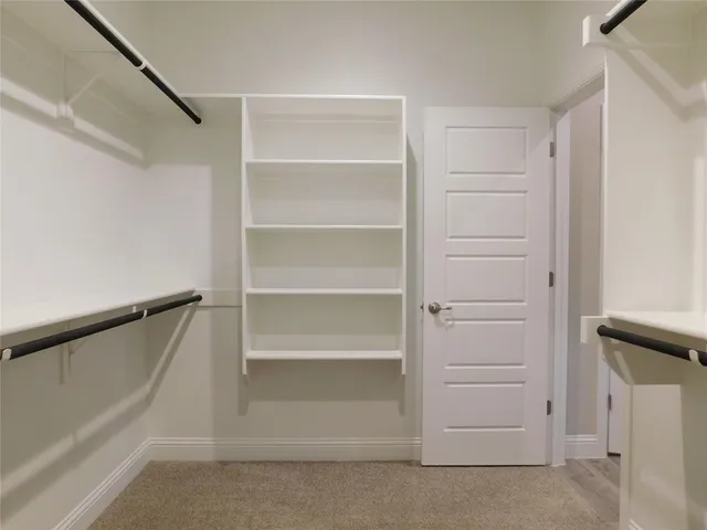 a view of walk in closet with empty racks
