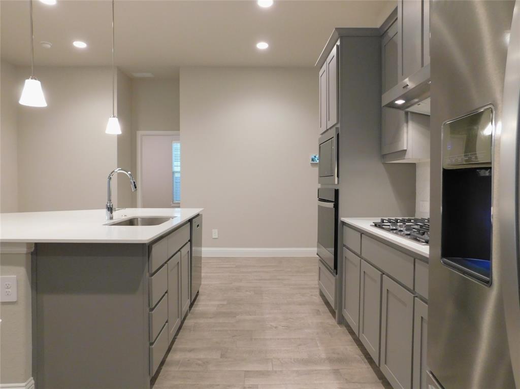 1708 Buzzard Road Denton, TX 76205 - Photo 6 of 28 a kitchen with stainless steel appliances granite countertop a sink and a refrigerator