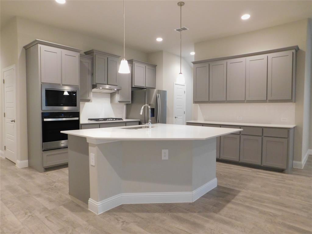 1708 Buzzard Road Denton, TX 76205 - Photo 7 of 28 a kitchen with kitchen island a sink stainless steel appliances and cabinets