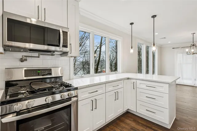 an empty room with wooden floor fireplace and windows