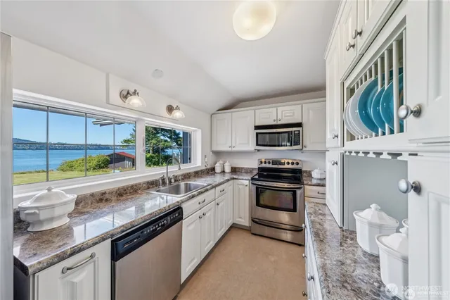 a kitchen with stainless steel appliances granite countertop a stove a sink and a microwave