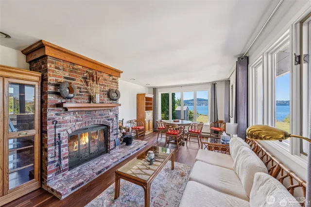 a living room with furniture fireplace and a large window
