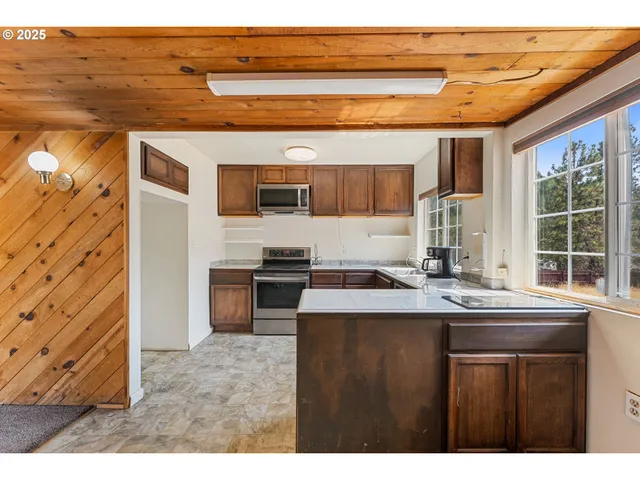 a kitchen with stainless steel appliances kitchen island a stove a sink and a refrigerator