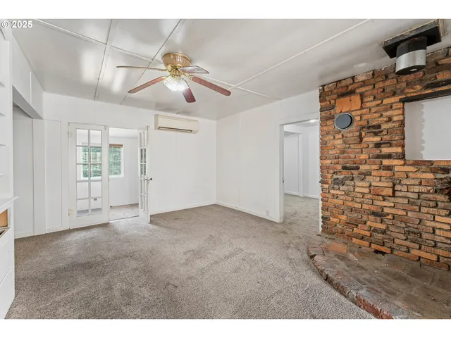 a view of an empty room and chandelier fan