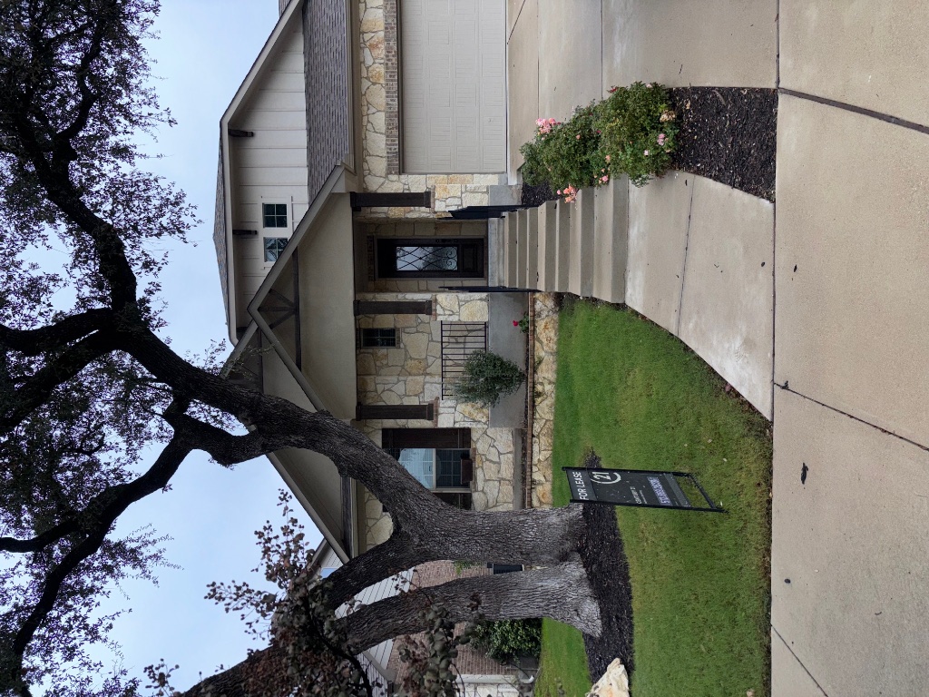 a front view of a house with a yard and trees