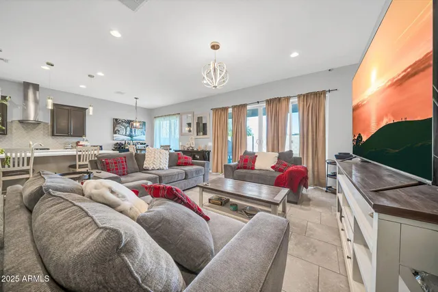 a living room with furniture a flat screen tv and a large window