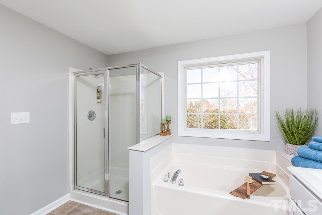 232 Seastone Street Raleigh, NC 27603 - Photo 13 of 20 a bathroom with a tub shower and window
