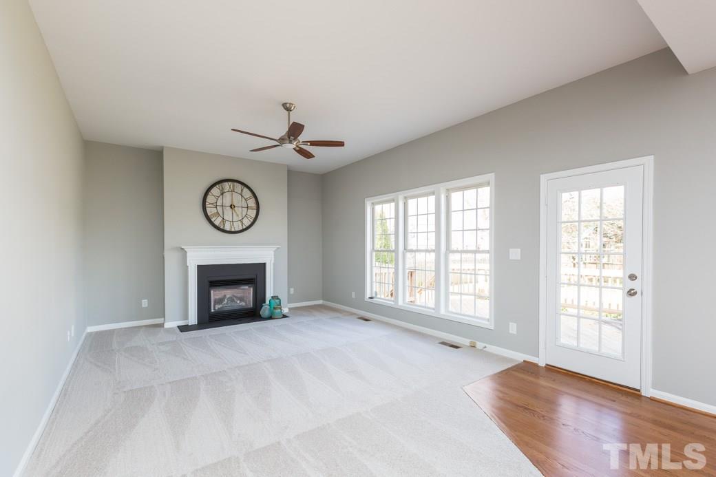 232 Seastone Street Raleigh, NC 27603 - Photo 6 of 20 a view of an empty room with a fireplace and a window