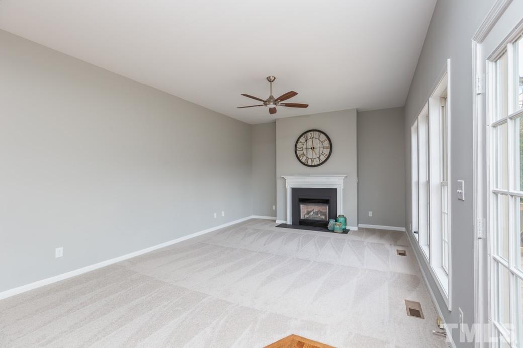 232 Seastone Street Raleigh, NC 27603 - Photo 7 of 20 a view of an empty room with a fireplace and a window