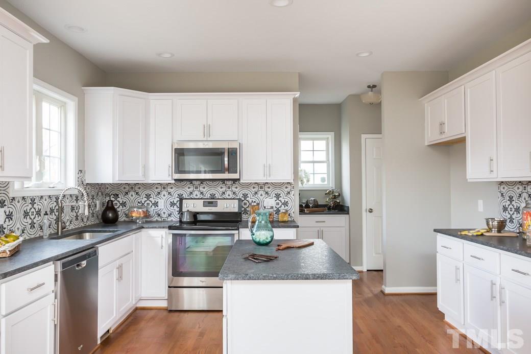 232 Seastone Street Raleigh, NC 27603 - Photo 9 of 20 a kitchen with sink a microwave and cabinets