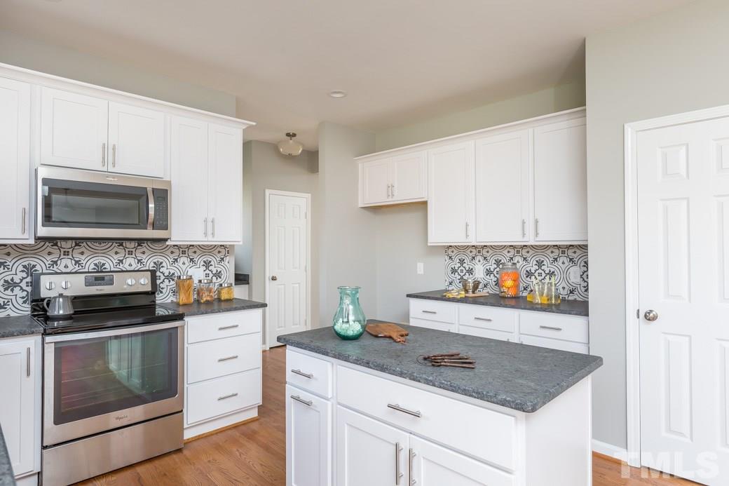 232 Seastone Street Raleigh, NC 27603 - Photo 10 of 20 a kitchen with white cabinets and appliances