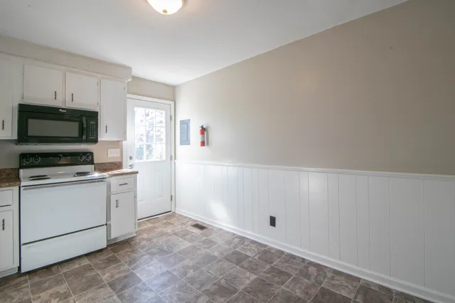 a kitchen with white cabinets and white appliances