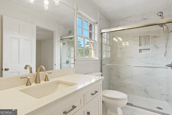 a bathroom with a bathtub shower and toilet