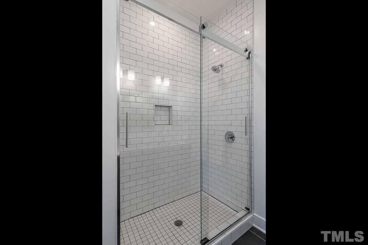 615 Daniels Street, Unit 318 Raleigh, NC 27605 - Photo 16 of 26 a bathroom with a glass shower door