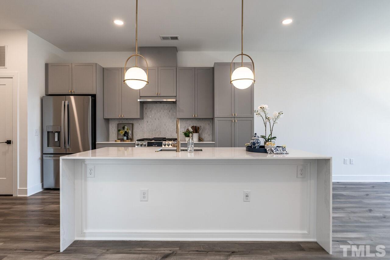 615 Daniels Street, Unit 318 Raleigh, NC 27605 - Photo 6 of 26 a kitchen with stainless steel appliances a sink and a refrigerator
