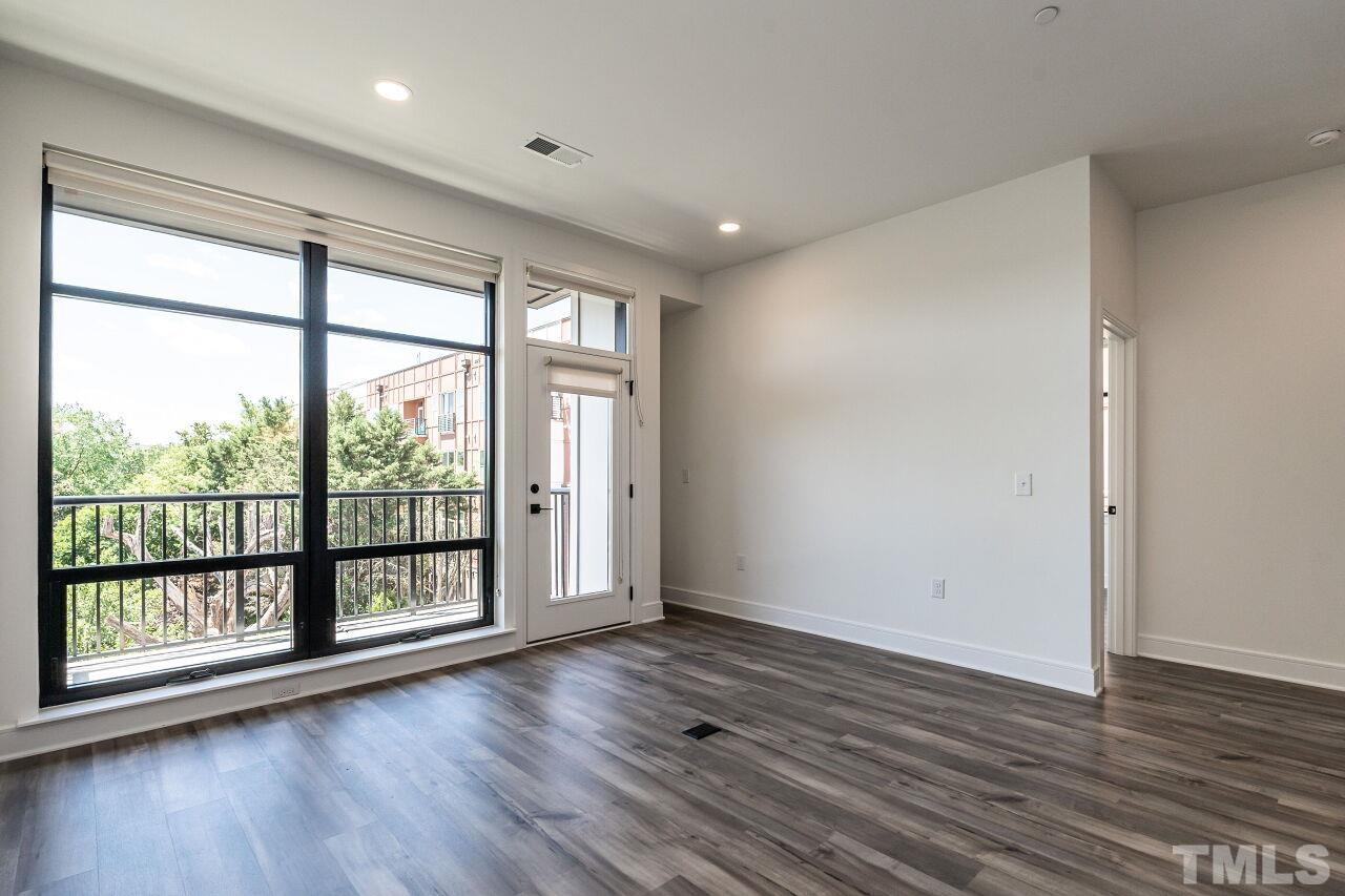 615 Daniels Street, Unit 318 Raleigh, NC 27605 - Photo 10 of 26 wooden floor in an empty room with a window