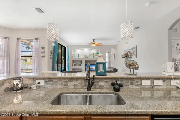 a living room with stainless steel appliances granite countertop furniture and a kitchen view