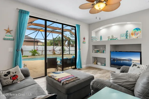 a living room with furniture and a floor to ceiling window