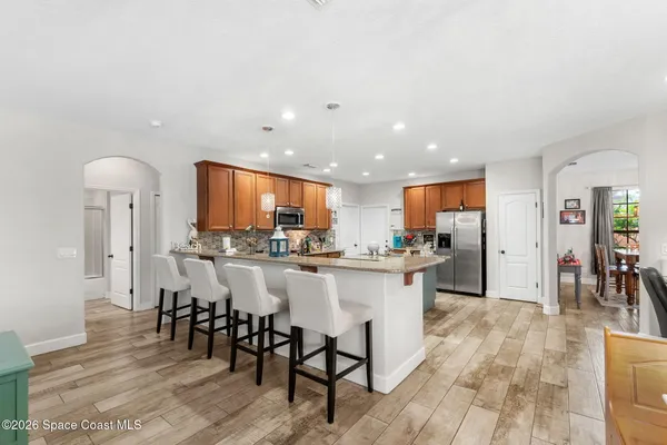 a kitchen with kitchen island a counter top space a sink cabinets and stainless steel appliances