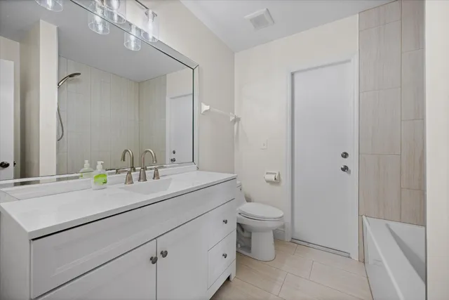 a bathroom with a granite countertop sink mirror and toilet