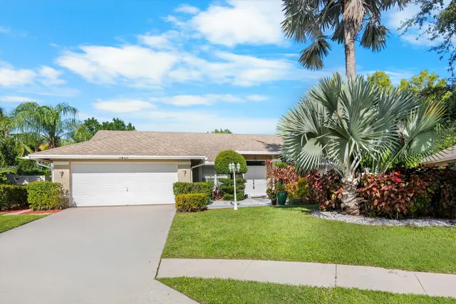 a front view of a house with a yard and potted plants