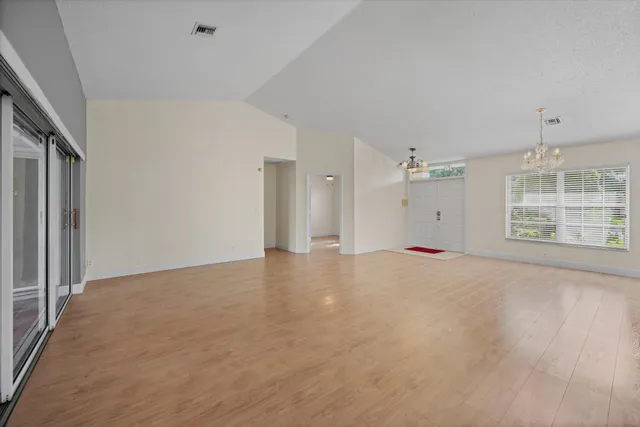 a view of a big room with windows and chandelier fan
