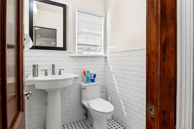 a bathroom with a toilet sink and mirror