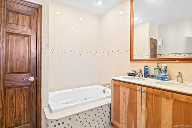 a bathroom with a bathtub a sink a vanity and a shower