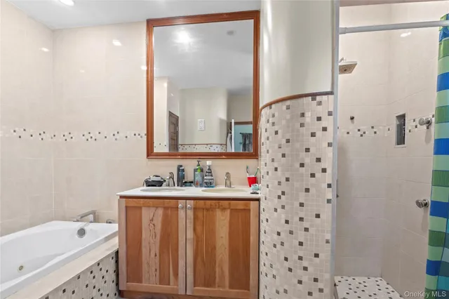 a bathroom with a sink a mirror a bathtub and a shower