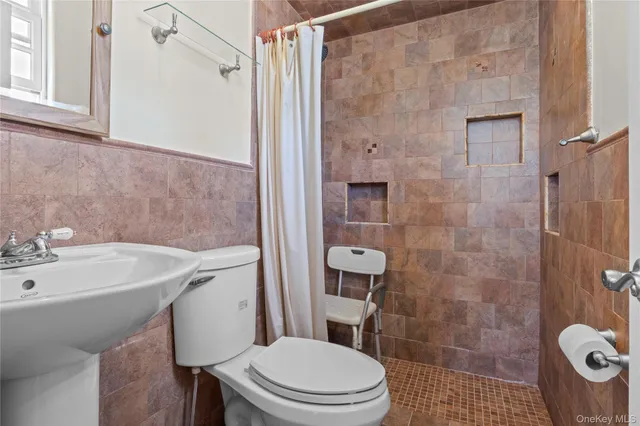 a bathroom with a sink a toilet a mirror and shower