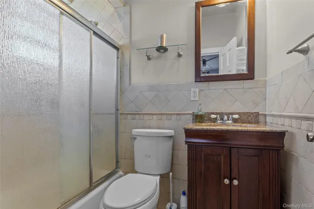 a bathroom with a granite countertop toilet sink and mirror