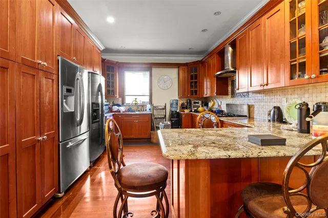 a kitchen with refrigerator a sink and chairs