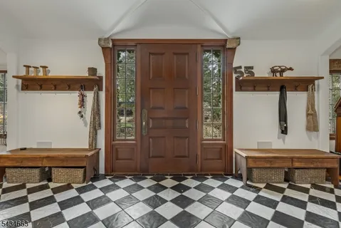 a living room with a black white checkered floor with couches and wooden floor