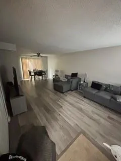 a living room with furniture and view of kitchen