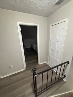 a view of a hallway with wooden floor and entryway