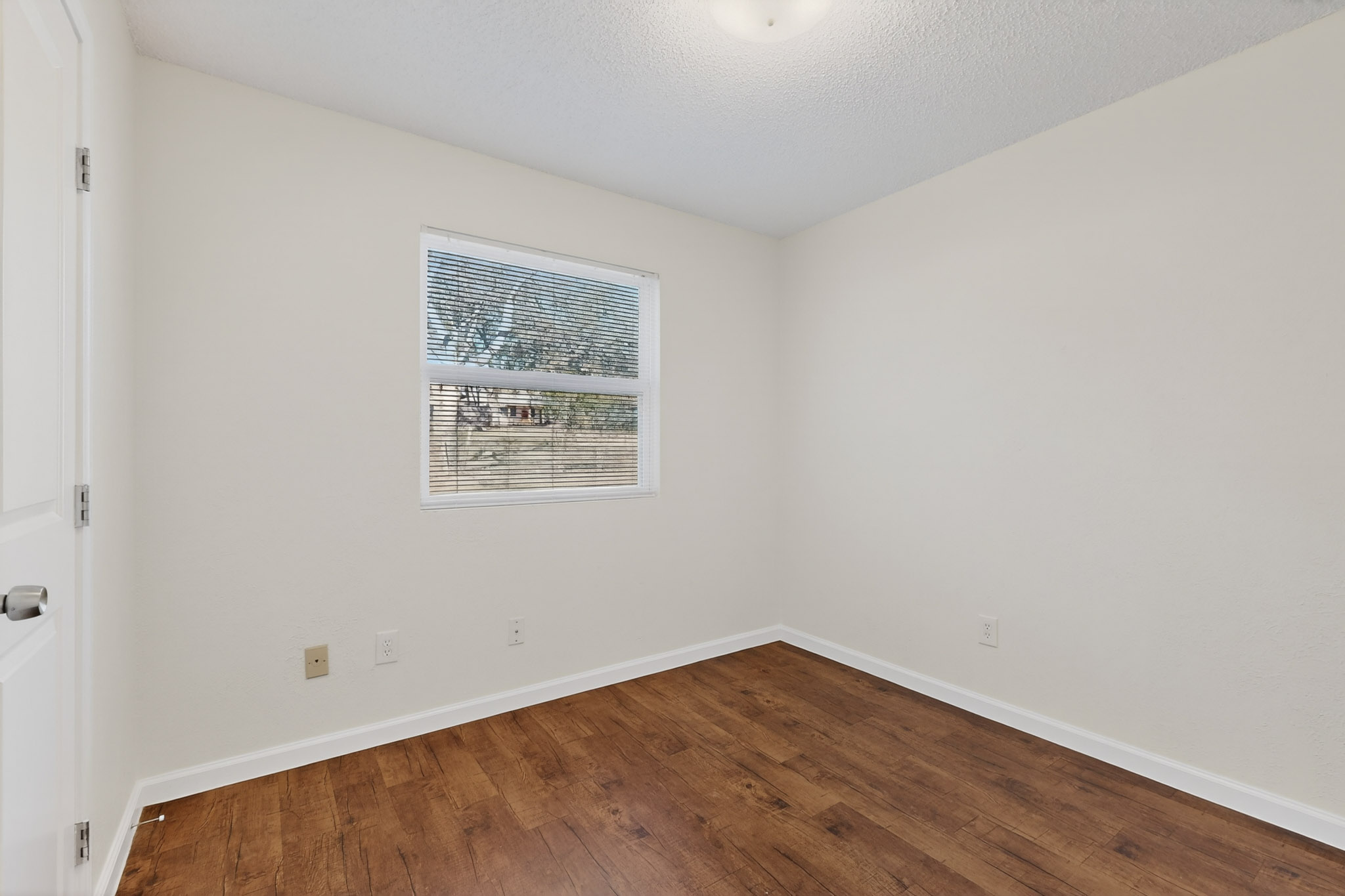 7200 Barnsdale Way Austin, TX 78745 - Photo 23 of 26 a view of an empty room with wooden floor and a window