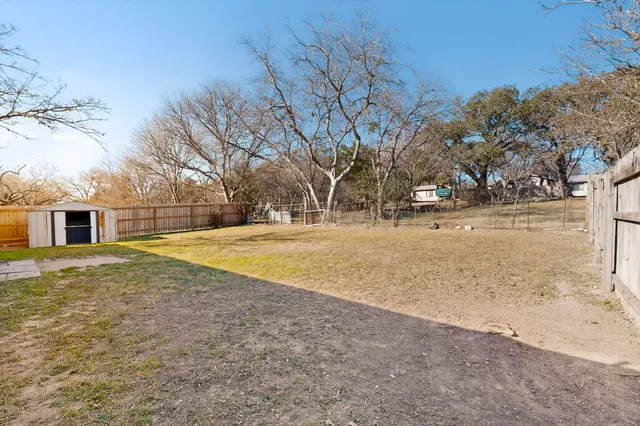 a view of yard with tree in front of it