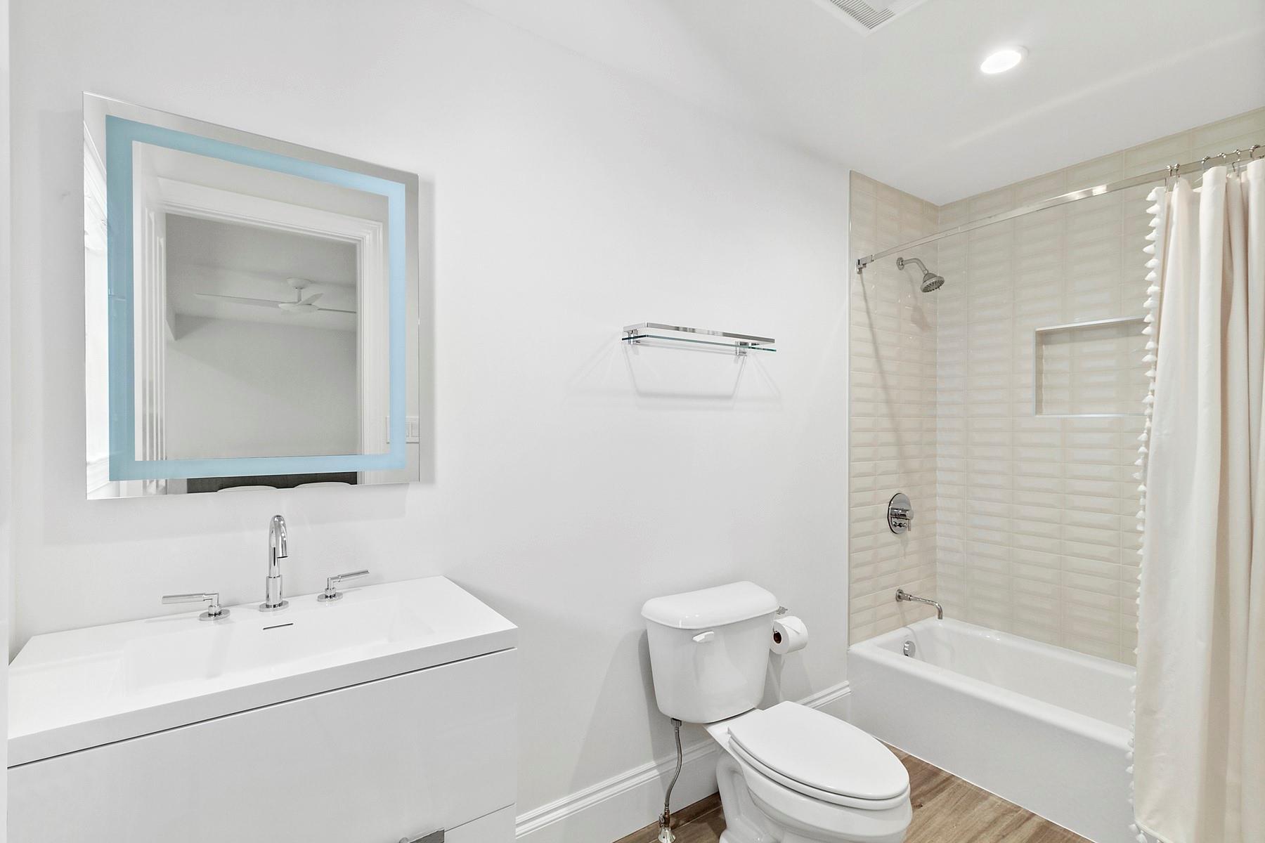 421 Edge Of Woods Road Southampton, NY 11968 - Photo 16 of 33 Full bathroom with shower / bathtub combination with curtain, vanity, and wood finished floors